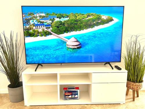 une télévision sur un stand avec une île à l'écran dans l'établissement Cozy house near Disney, Knott’s & Beach!!, à Fullerton
