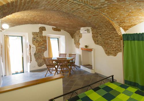 Cette chambre dispose d'une table, de chaises et d'un mur en briques. dans l'établissement Bed&Braja, à Vische