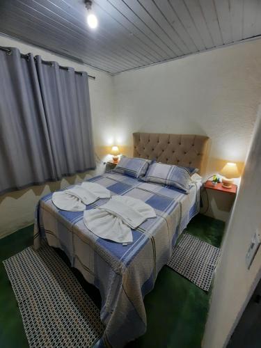 - une chambre avec un grand lit et des serviettes dans l'établissement Morada Jaguary, à Camanducaia