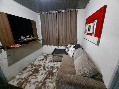 ein Wohnzimmer mit Sofa und Fernseher in der Unterkunft Morada Jaguary in Camanducaia