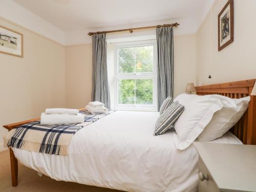 a bedroom with a large bed with a window at Banneth in Mawgan in Meneage