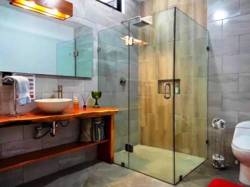 ein Bad mit einer Glasduschkabine und einem Waschbecken in der Unterkunft LINA - Confortable depto con alberca climatizada. in Mazatlán