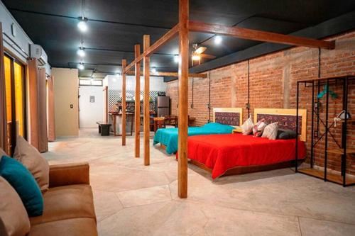ein Schlafzimmer mit einem roten Bett und einer Ziegelwand in der Unterkunft LINA - Confortable depto con alberca climatizada. in Mazatlán