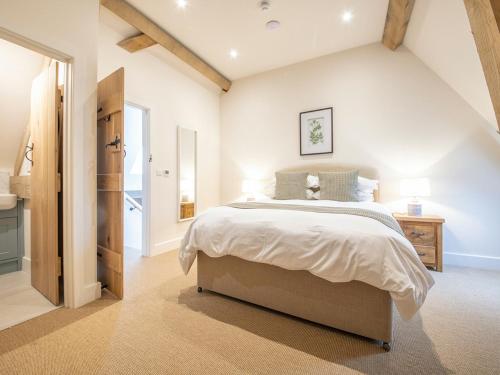 a bedroom with a large bed and a bathroom at Olivers Barn - Uk42081 in East Garston