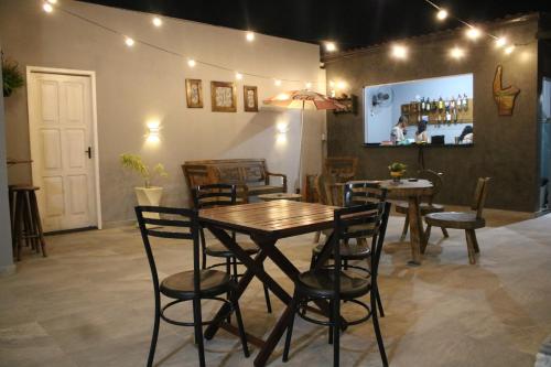 a dining room with two tables and chairs and a screen at Suítes do Cabo in Arraial do Cabo