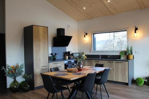 eine Küche mit einem Tisch und Stühlen im Zimmer in der Unterkunft Gîte chalet, Au Doubs Logis in Pierrefontaine-les-Varans