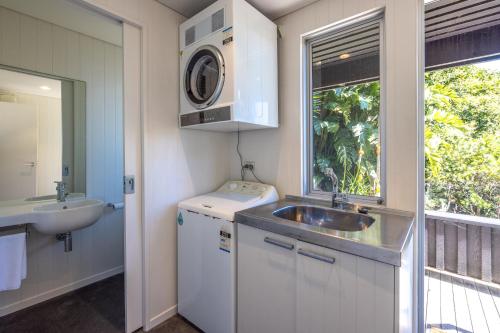 a small kitchen with a sink and a washing machine at Black Bach in Onetangi