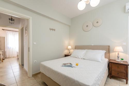 Un dormitorio con una cama con un libro. en Villa of Roses in Naxos - Private villa with pool, en Naxos Chora