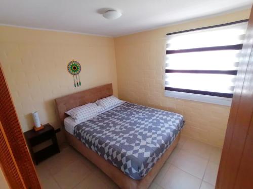 a small bedroom with a bed and a window at Casa en Padre Hurtado IV in Talagante