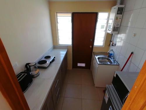 uma pequena cozinha com um balcão e um lavatório em Casa en Padre Hurtado IV em Talagante