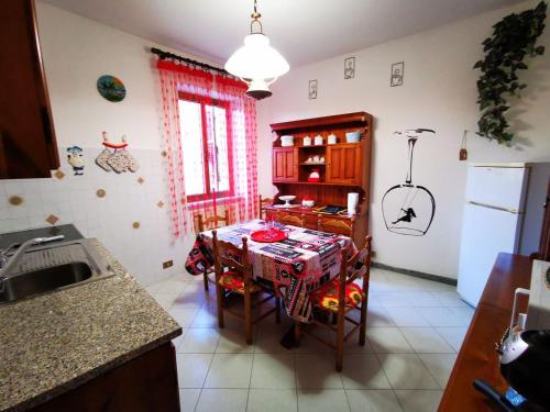 a kitchen with a table with chairs and a sink at La Casa di Lice in Moneglia