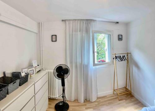 a white room with a window and a fan at Bel Appart Alfortville -Quai Seine - 5mn de Paris in Alfortville
