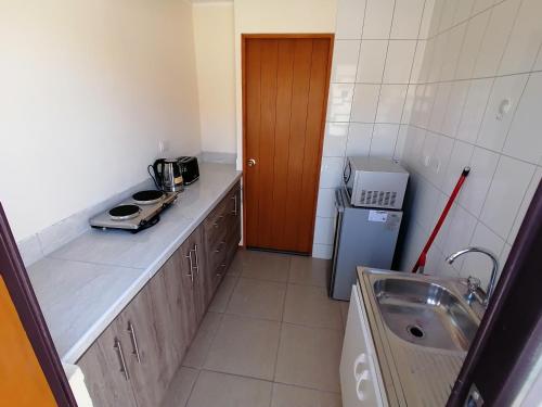 a small kitchen with a sink and a refrigerator at Agradable casa en Padre Hurtado VI in Talagante