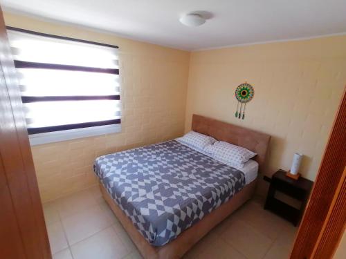 a small bedroom with a bed and a window at Agradable casa en Padre Hurtado VI in Talagante