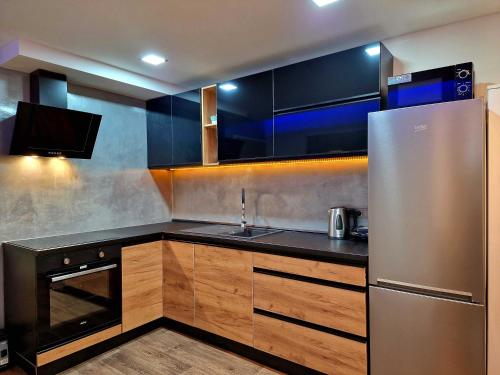 eine Küche mit einem Kühlschrank aus Edelstahl und einer Spüle in der Unterkunft Wellness Gold apartment with Private SAUNA & JACUZZI in Prag