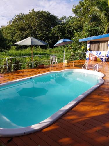 a swimming pool on a deck with an umbrella at Natalias Beach House in Matapalo