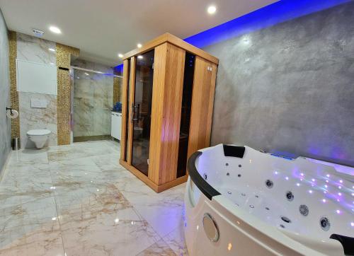 ein großes Bad mit einer Badewanne und einem WC in der Unterkunft Wellness Gold apartment with Private SAUNA & JACUZZI in Prag