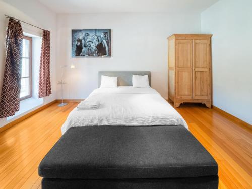 a bedroom with a large bed and a wooden floor at Welcoming holiday home in Dison with private pool in Dison