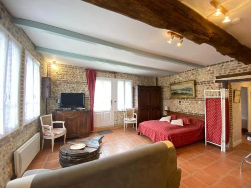 un salon avec un lit et un canapé dans l'établissement Cottage near Étretat Cliffs with Private Garden, à La Poterie-Cap-dʼAntifer