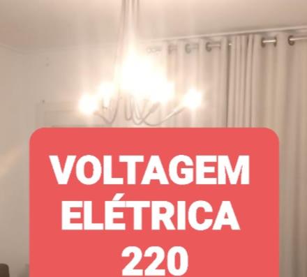 un cartello rosso con la scritta voltageenergy elefrica di NA BEIRA MAR DE PAJUCARA- EDIF NEO- APARTAMENTO QUARTO E SALA - POSSUI VARANDA- VISTA LATERAL DO MAR-RUA JULIO PLECH FILHO 60 ESQUINA COM AVENIDA DOUTOR ANTONIO GOUVEIA - CONSUMO ELETRICO É PAGO No CKECK-OUT - 1 KWH É 1,35 REIAS a Maceió