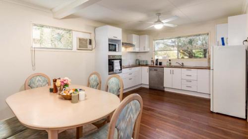 a kitchen and dining room with a table and chairs at Pet Friendly Cottage With Waterviews in Bongaree