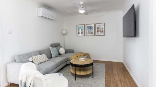 a living room with a couch and a table at Beach Shack Bongaree in Bongaree