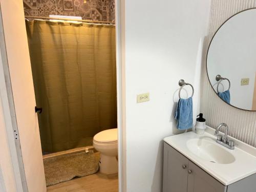 a bathroom with a toilet and a sink and a mirror at Casa Manila ALBERCA TERRAZA Y ACCESO A PLAYA in Bahía Kino