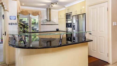 a large kitchen with a glass counter top at Paradise On Banksia Canal in Banksia Beach