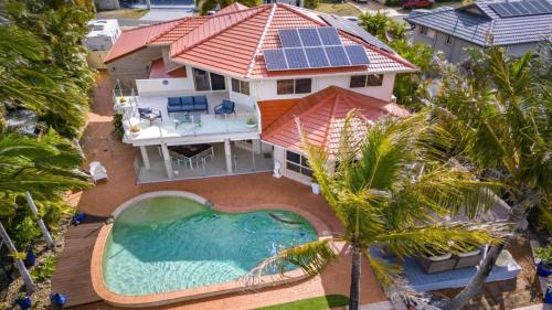 an aerial view of a house with a swimming pool at Paradise On Banksia Canal in Banksia Beach