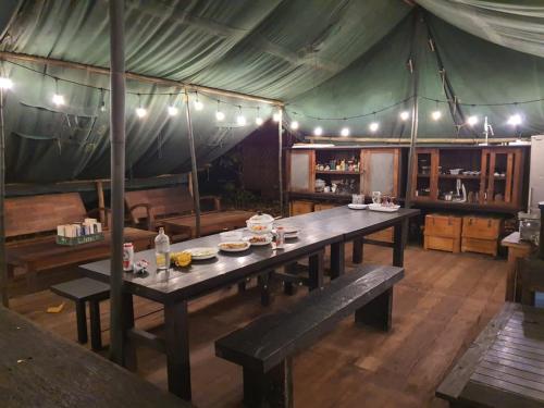 a dining room with a table in a tent at Camp Tarimbang in Tandulujangga