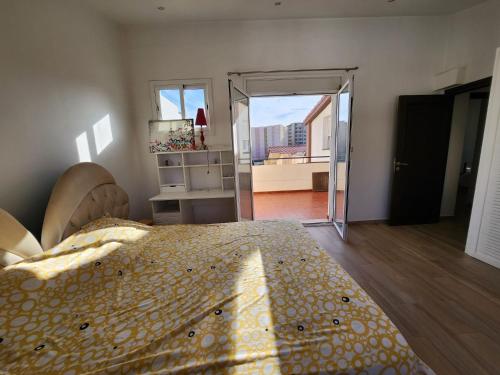 a bedroom with a bed and a door to a balcony at beaux duplex in Deli Ibrahim