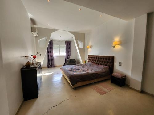 a bedroom with a large bed and a mirror at beaux duplex in Deli Ibrahim