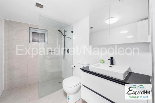 ein weißes Bad mit einem WC und einem Waschbecken in der Unterkunft Napoleon On Kent in Sydney