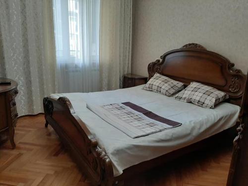 a bed with a wooden headboard with a keyboard on it at Apartment ЖУЖУНА in Batumi