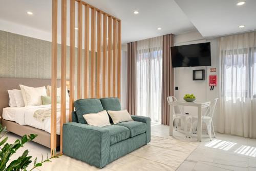 a bedroom with a bed and a couch and a chair at Beco Santa Emilia 4Q, a Home in Madeira in Funchal