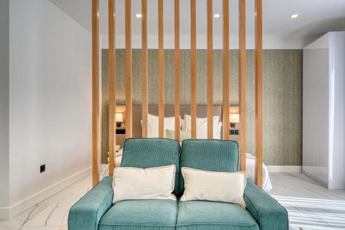 a living room with a blue couch and a bed at Beco Santa Emilia 4Q, a Home in Madeira in Funchal