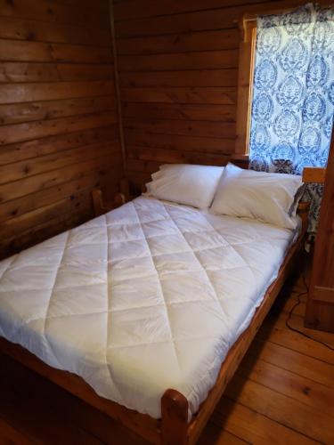 a bedroom with a bed in a log cabin at Shenandoah 1 Summer Camp in the Laurel Highlands in Champion