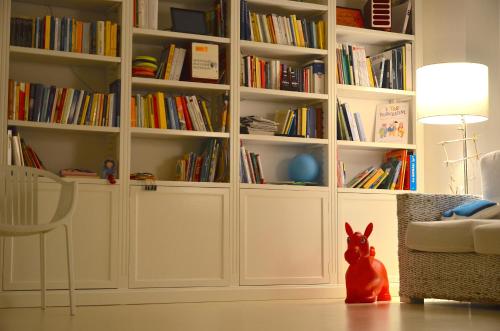 a room with white book shelves filled with books at Petit Hotel in Lido di Camaiore