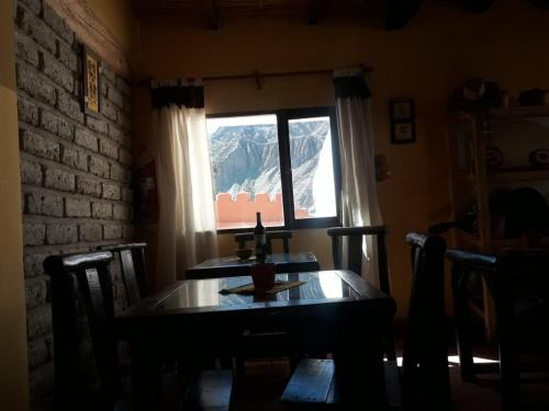 uma sala de jantar com uma mesa e uma janela em Hotel Cactus Cerro em Purmamarca