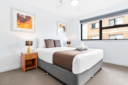 a bedroom with a large bed and a window at Windward Apartments in Mooloolaba
