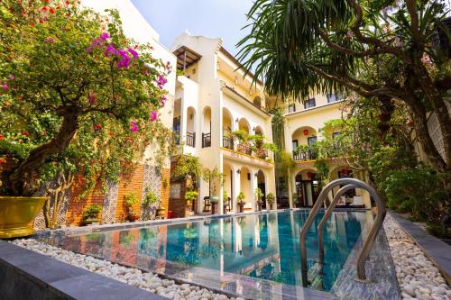 a swimming pool in the courtyard of a building at Little Town Villa in Hoi An