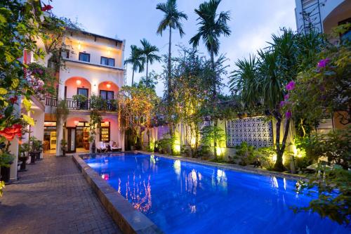 a large swimming pool in front of a building at Little Town Villa in Hoi An