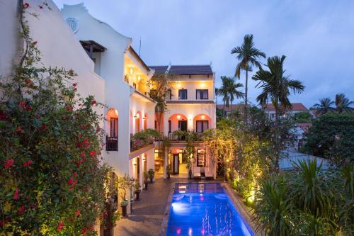 an exterior view of a house with a swimming pool at Little Town Villa in Hoi An