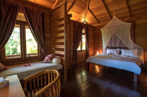 a bedroom with two beds in a wooden cabin at K2 Lembeh Dive Resort in Bitung