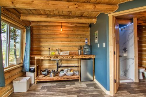 a kitchen with wooden walls and a counter with a sink at The Raven's Nest Resort & Campground in Fairmont Hot Springs