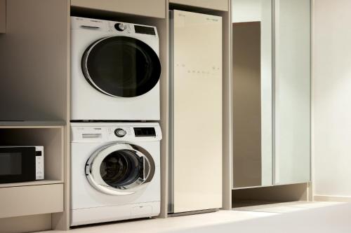 a washing machine and a microwave in a kitchen at The Connoisseur Residence Hotel in Seoul