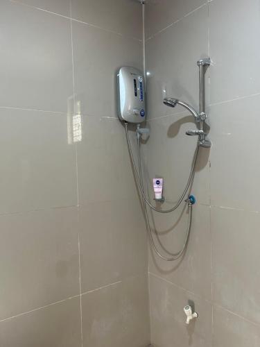 um chuveiro na casa de banho com um telefone na parede em Brown Gate House em Panabo