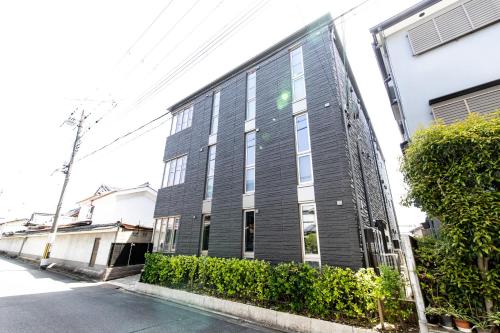 a black building on the side of a street at Oyado Nishishichijo in Kyoto