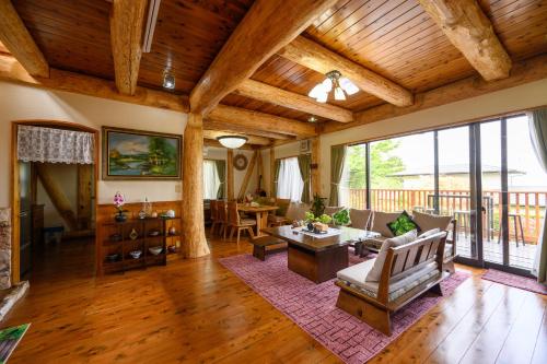 a living room with wooden ceilings and a large window at 貸温泉別荘Clover天城杉のログハウス伊豆高原 in Ito