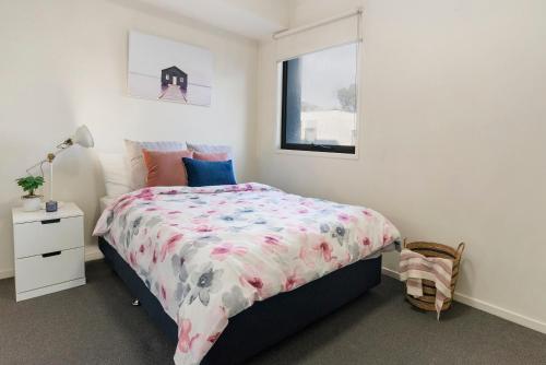 een slaapkamer met een bed en een raam bij A Comfy & Cozy 2BR Apt Near Flemington Races in Melbourne